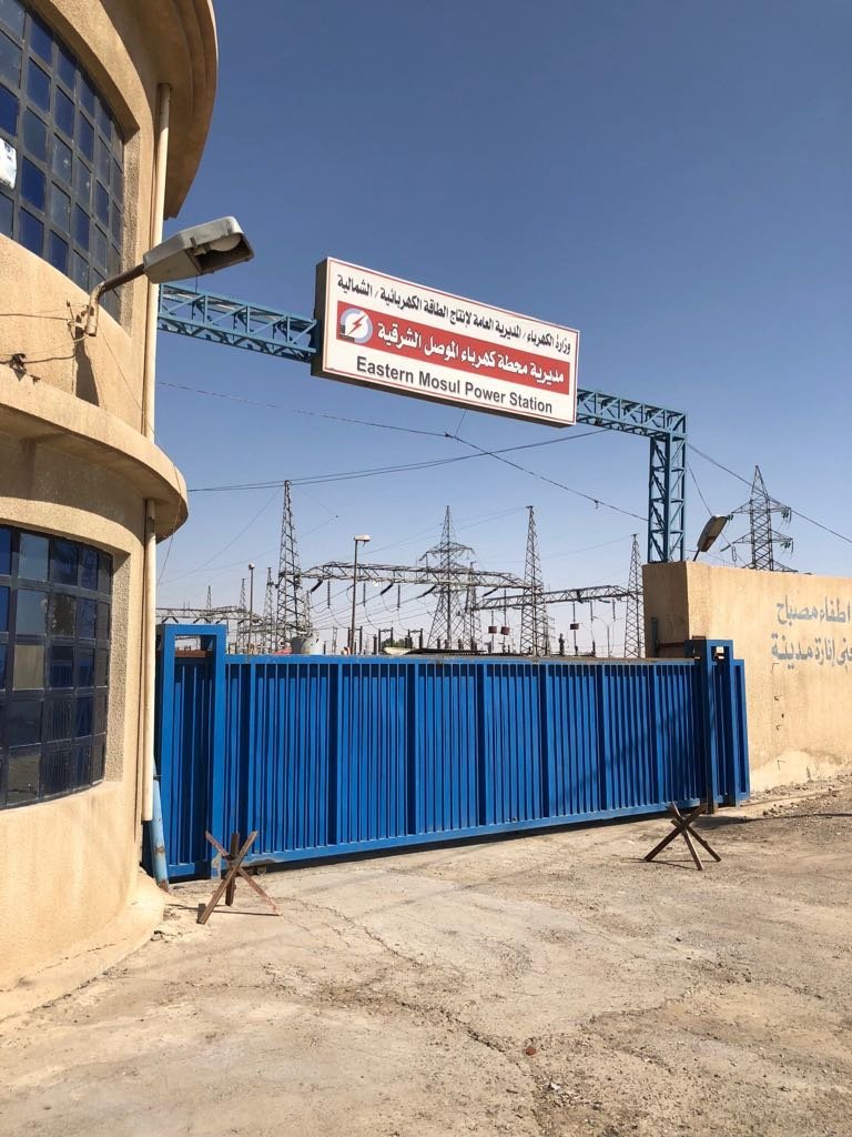 A blue gate with a sign above it
Description automatically generated