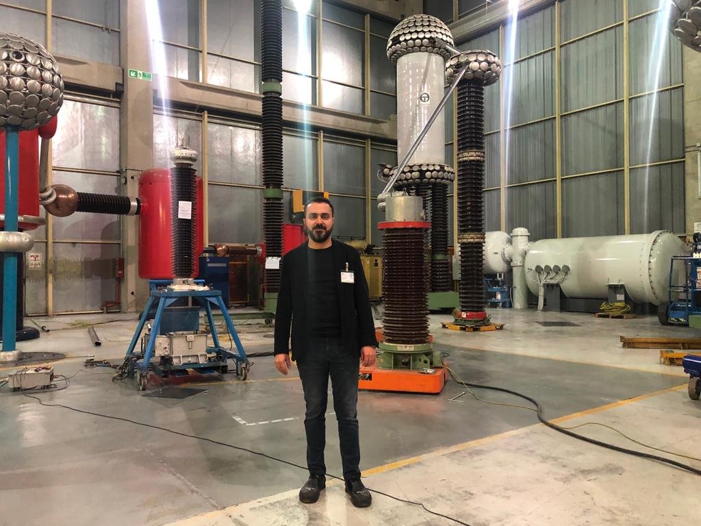 A person standing in a factory
Description automatically generated